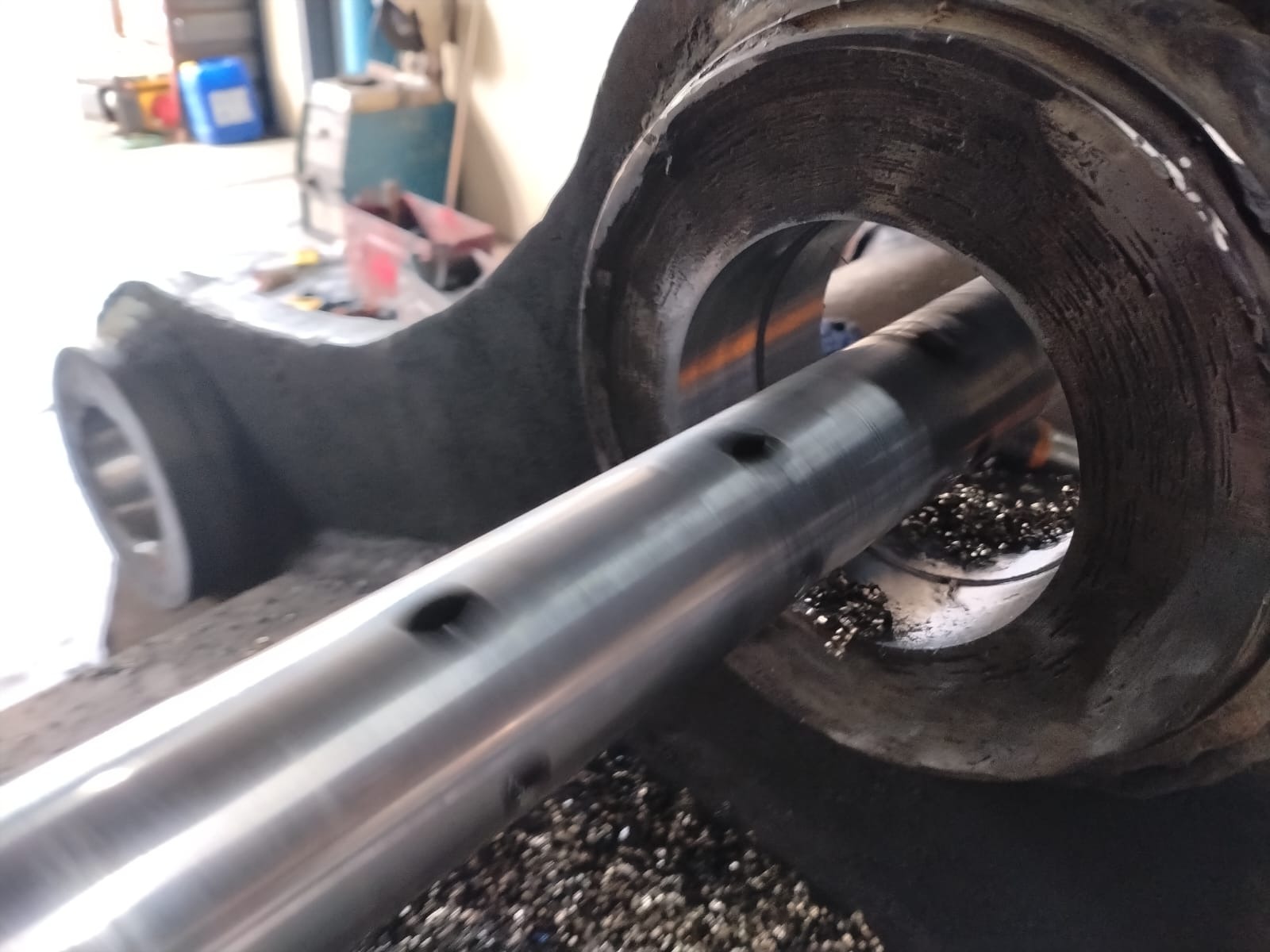 Precision-machined boring shaft passing through bucket lug